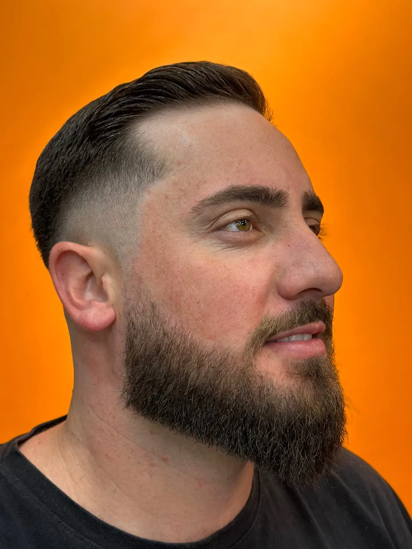 Cliente com barba cheia alinhada e degradê na Swarowski